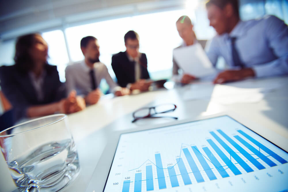 Consultor financeiro discutindo estratégias de investimento com um grupo diverso.