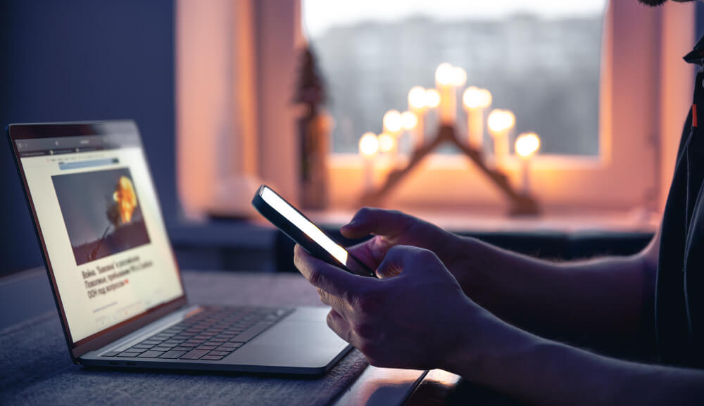 Investidor utilizando ferramentas financeiras no computador e smartphone.
